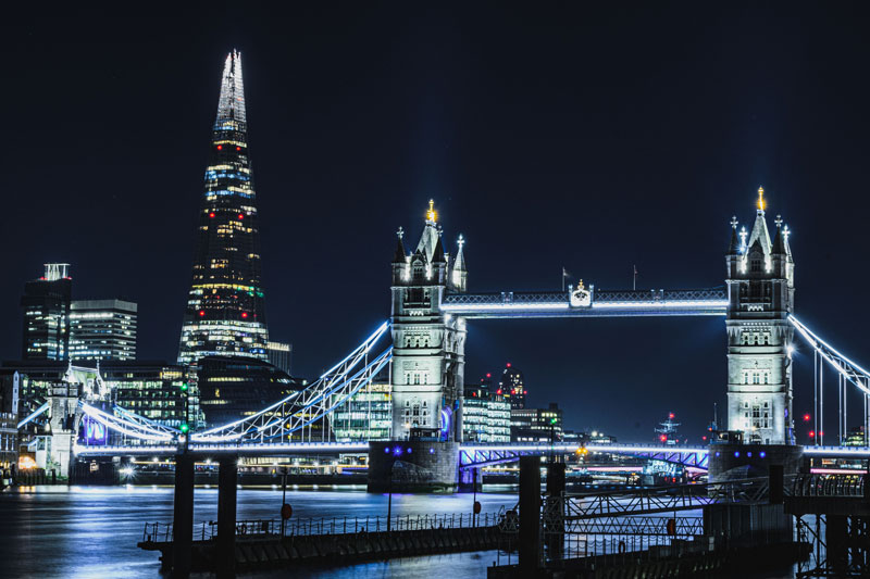 Night view of Tower Bridge in London illuminated with lights, reflecting on the River Thames – Energi IQ – Energy Assessment Services, energy assessment services ireland, energy assessment services uk, energy compliance experts, sustainable building solutions.